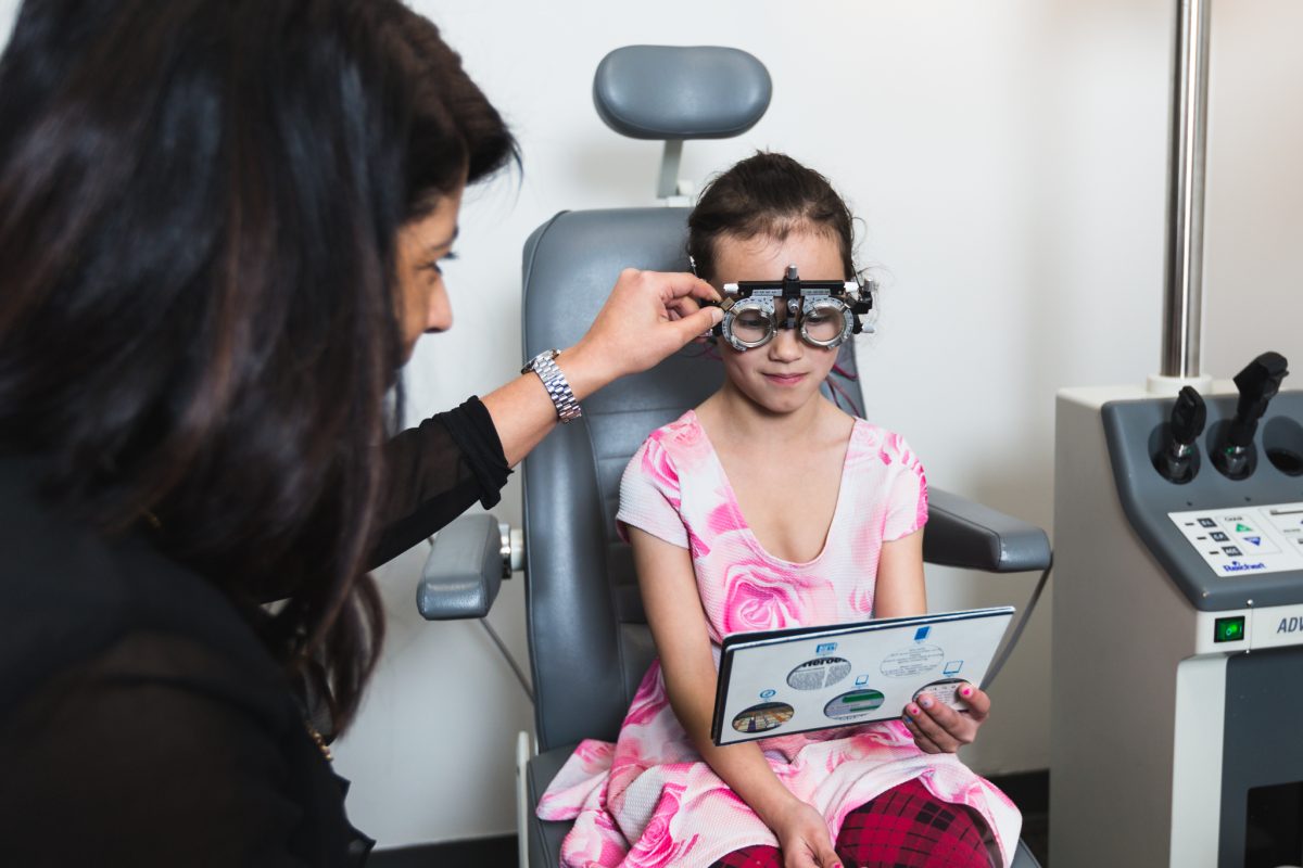 Child receiving eye exam with an optometrist