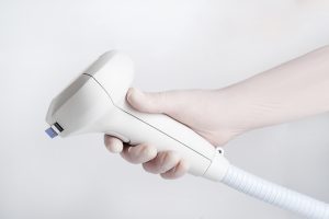 The inMode Lumecca applicator held in a gloved hand