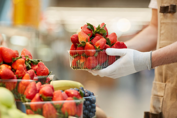 A farmer holds a basket of strawberries at a Saanich farmers market.